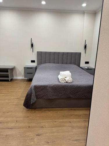 a bedroom with a bed with two towels on it at Уютная квартира в центре города in Almaty