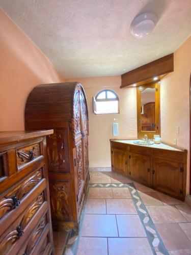 a bathroom with a sink and a large wooden cabinet at nice vacation home in Zihuatanejo