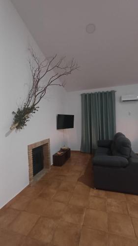 Una sala de estar con un sofá y una chimenea. en Casas rurales La Colada, en El Viso