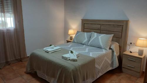a bedroom with a bed with two towels on it at Casas rurales La Colada in El Viso