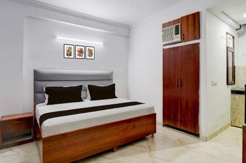 a bedroom with a bed and a wooden cabinet at Hotel O THE PRAVAHA in Noida