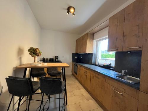 a kitchen with a table and some chairs and a sink at Gutshof von Gemünden Ferienwohnung 4 in Bernau bei Berlin