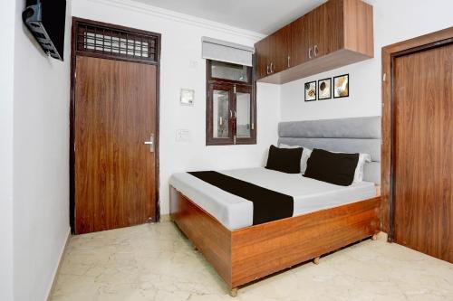 a bedroom with a bed and a wooden door at Hotel O THE PRAVAHA in Noida