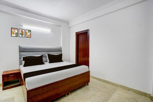 a bedroom with a bed in a white room at Hotel O THE PRAVAHA in Noida