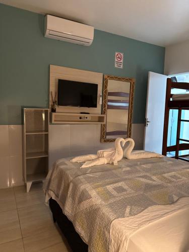 a bedroom with a bed with a mirror and a tv at Chalé Temporada Porto dos Lençóis - Lençóis Maranhenses in Barreirinhas