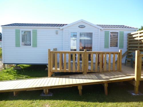 a small white house with a wooden deck at Auberge des Etangs in Roussent