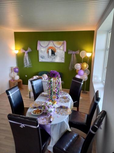 a dining room with a table with chairs and balloons at Big House Near Beach & Lake in Haderslev