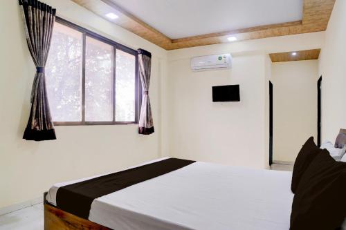 a bedroom with a bed and a window at Hotel O Bhiwandi Road Railway Station Formerly Shivneri in Bhiwandi