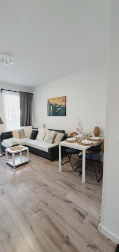 een woonkamer met een bank en een tafel bij Good Time Apartments 104 Komfortowy apartament w sercu Starego Miasta in Poznań