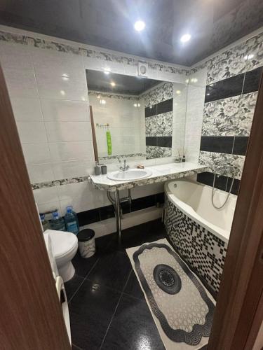 a bathroom with a sink and a tub and a toilet at Коротченко 31 in Golta