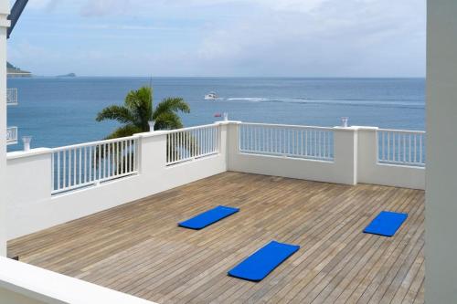 a balcony with two blue lounge chairs on the beach at Fort Young Hotel in Roseau