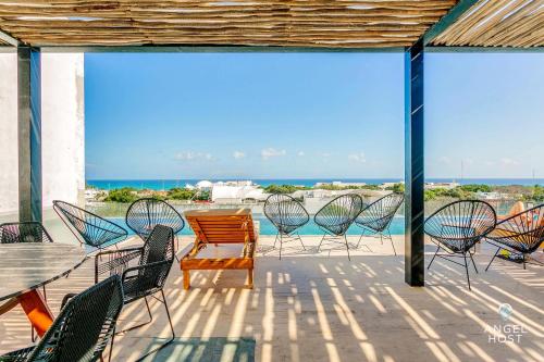プラヤ・デル・カルメンにあるNEW Downtown Stay with Oceanview Roof Pool and Gym plus Cafeのパティオに置かれた椅子とテーブルの集まり