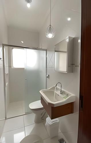 a bathroom with a sink and a toilet and a shower at Costa Family-Apartment in the center in Santa Rita do Sapucaí