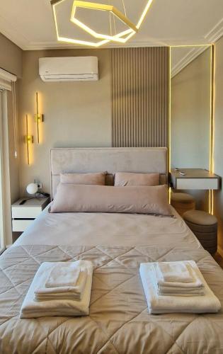 a bedroom with a large bed with two towels on it at Kaltak Luxury Stay in Bar