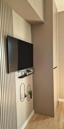 a flat screen tv hanging on a wall at Kaltak Luxury Stay in Bar