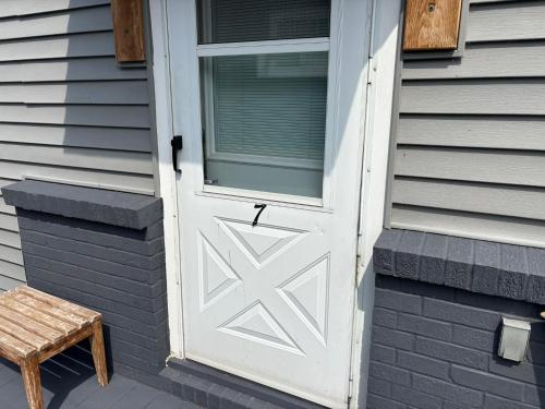 a white door on the side of a house with a stool at Pleasant Valley Resort in Arcadia