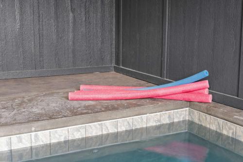 two pink and blue towels sitting on the edge of a swimming pool at Lake View Serenity - Indoor Pool - Arcade - Lake in Sevierville