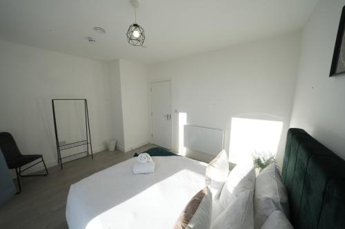 a bedroom with a large white bed and a chair at Ealing Broadway Great Stay 7-Minute Walk from the Underground in Ealing