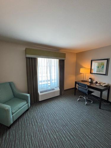 a hotel room with a desk and a chair at Ramada by Wyndham Burkburnett - Wichita Falls in Burkburnett