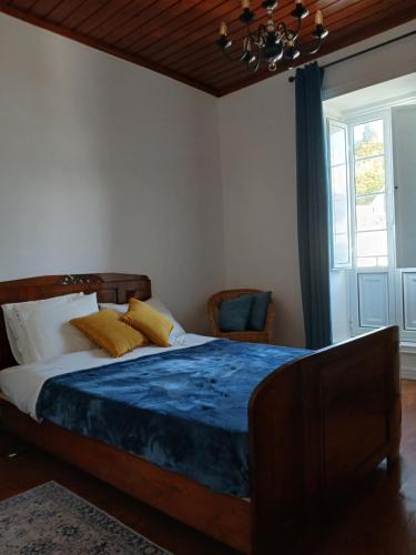 a bedroom with a bed and a window and a chandelier at Botânico Guesthouse in Nordeste