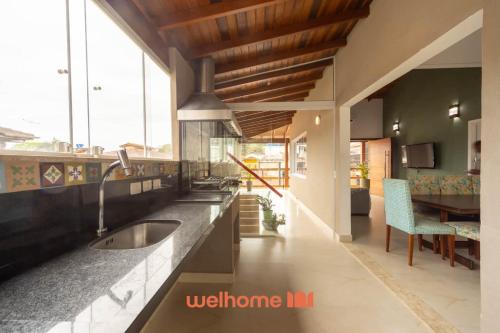a kitchen with a sink and a dining room at Casa em Maresias com Churrasqueira e area de lazer in Maresias