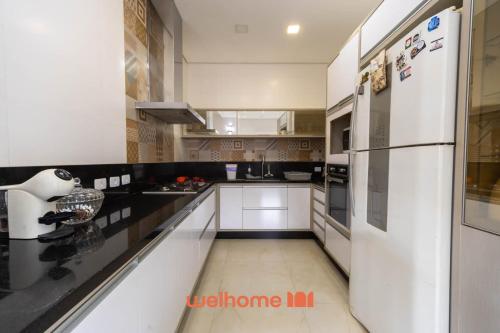 eine Küche mit weißen Geräten und einem weißen Kühlschrank in der Unterkunft Casa em Maresias com Churrasqueira e area de lazer in Maresias