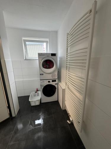 a laundry room with a washing machine and a washer at Geräumige Zimmer in zentraler Lage in Prisdorf