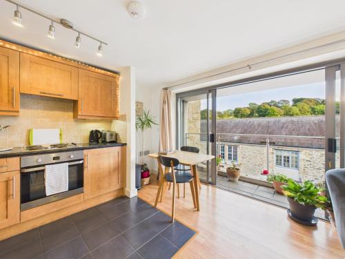 a kitchen with a table and a large window at Penryn Quayside Apartment – 1-bed, Fully Equipped Waterside base in Penryn