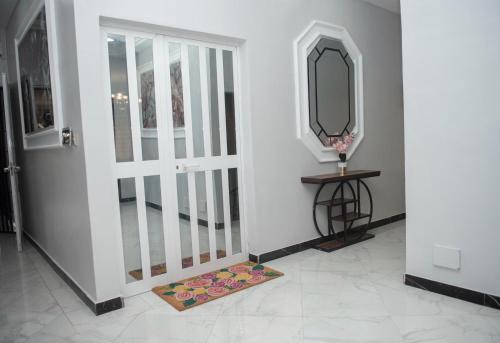 a hallway with a door with a mirror and a mat at YOYO'S hOME SWEET HOME in Komé