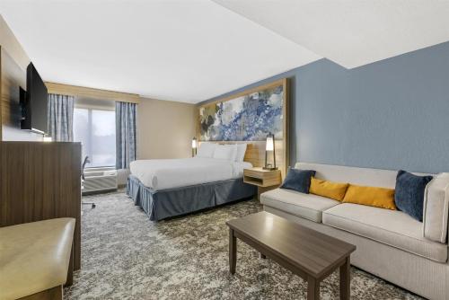 a hotel room with a bed and a couch at Best Western Plus Sanford Airport/Lake Mary Hotel in Sanford
