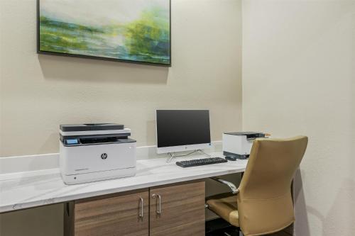 a desk with a computer and a printer and a chair at Best Western Plus Sanford Airport/Lake Mary Hotel in Sanford