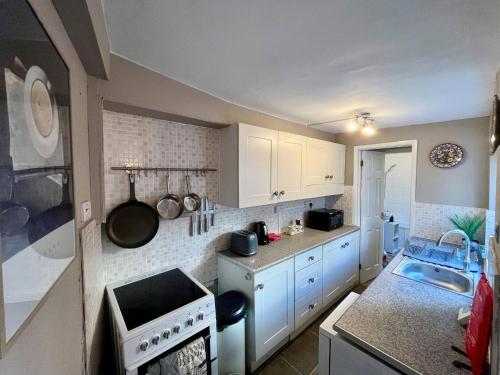 a small kitchen with white cabinets and a sink at 3 Bedrooms house in center l Contractor l Family l in Gloucestershire