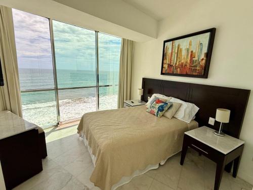 a bedroom with a bed with a view of the ocean at Park Royal 809 Vista al Mar in Mazatlán