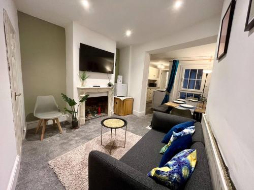 a living room with a couch and a fireplace at 3 Bedrooms house in center l Contractor l Family l in Gloucestershire