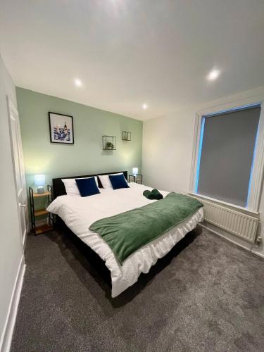 a bedroom with a large white bed with blue pillows at 3 Bedrooms house in center l Contractor l Family l in Gloucestershire