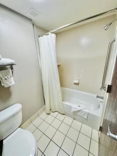 a bathroom with a toilet and a bath tub at Motel 6-Milford, CT in Milford