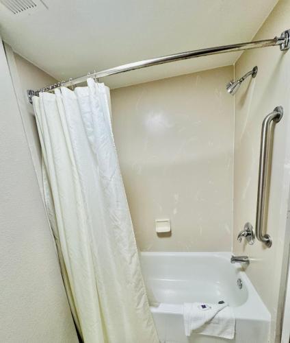a bathroom with a bath tub and a shower curtain at Motel 6-Milford, CT in Milford