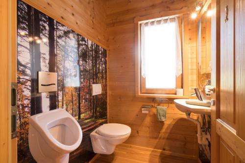 ein Badezimmer mit einem WC, einem Waschbecken und einem Urinal in der Unterkunft Chalet Leitn-Anger in St. Leonhard in Passeier