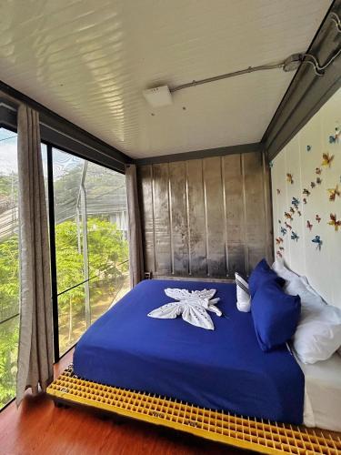 a bed in a room with a large window at Capsule Pupa House in Tamarindo
