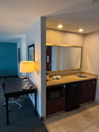 a room with a desk with a sink and a mirror at Ramada by Wyndham Burkburnett - Wichita Falls in Burkburnett