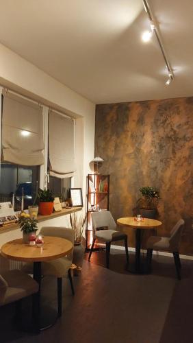 a living room with two tables and chairs at B&B Beyond in Nittel