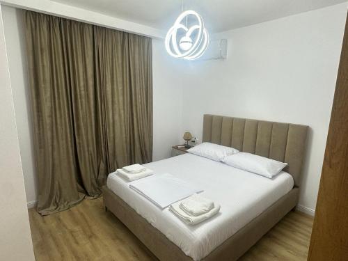 a bedroom with a bed with two towels on it at Amea Apartments in Durrës