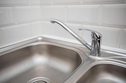 a stainless steel sink with a faucet in a kitchen at St James Court Aparthotel in Derby
