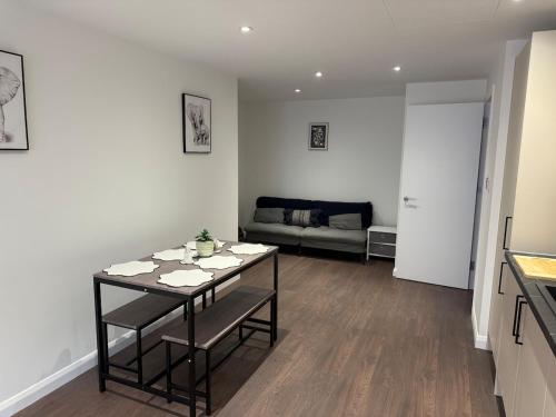 a living room with a table and a couch at Cosy Chic - On The High Street in Swindon