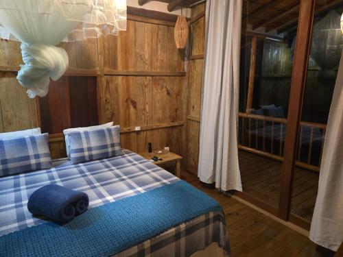 una camera da letto con un letto con una coperta blu e bianca di Pousada Lua Cheia Caraíva a Caraíva