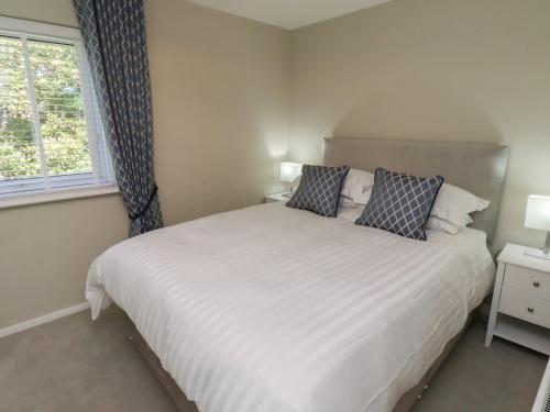 a bedroom with a white bed and a window at Seaspray in Beadnell
