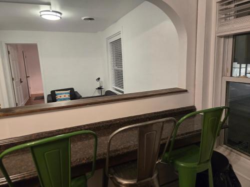 a bar with green chairs and a mirror at Grand House in Chicago
