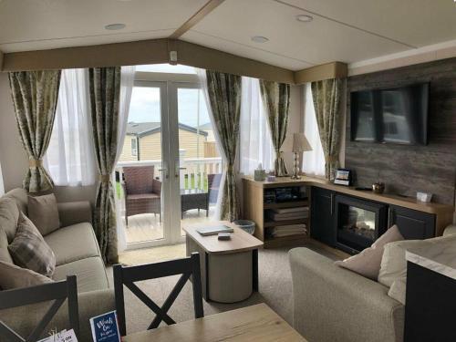 a living room with a couch and a fireplace at Littlesea Holiday Park - Holiday Accommodation 15976 in Wyke Regis