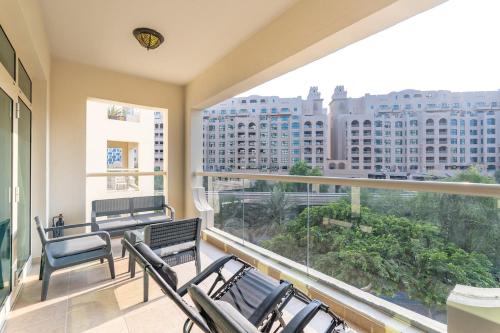 a balcony with chairs and a view of a city at Free housekeeping visits during your stay - StayShort - Elegant 1BR Haven for 3 in Palm Jumeirah in Dubai
