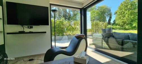 TV a/nebo společenská místnost v ubytování Le Fermage - logement avec piscine, sauna et jacuzzi